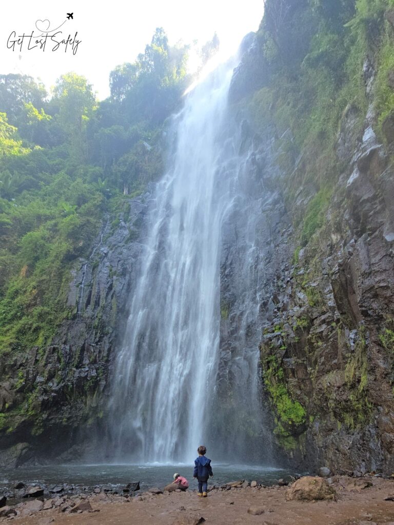 Anak-anak bermain di bawah air terjun raksasa setinggi 80 meter