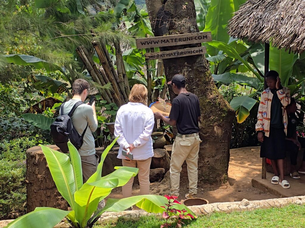 Tourists attending coffee tour in Materuni Homes, Tanzania. The guide is cleaning the coffee beans from its shell before the roasting it.